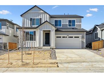 Two-story house with gray siding, white trim, and a two-car garage at 9083 Truckee Ct, Commerce City, CO 80022