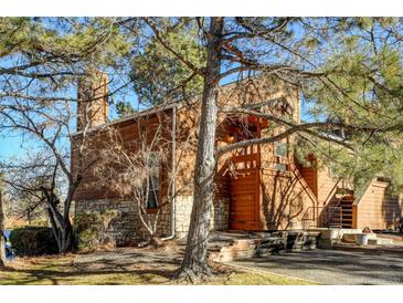 Exterior view of a charming log cabin-style home with stone accents at 4201 S Richfield Way, Aurora, CO 80013