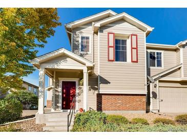 Two-story townhome with red door and brick accents, offering curb appeal at 13042 Grant E Cir # C, Thornton, CO 80241