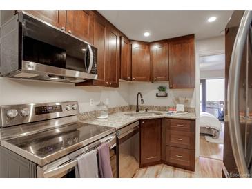 Modern kitchen with stainless steel appliances and granite countertops at 1885 S Quebec Way # H15, Denver, CO 80231