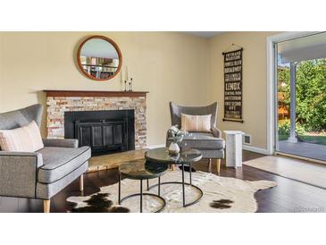 Cozy living room with a fireplace, two armchairs, and a cowhide rug at 470 S Kingston Cir, Aurora, CO 80012