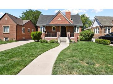 Brick house with a walkway, lawn, and driveway at 1529 Holly, Denver, CO 80220