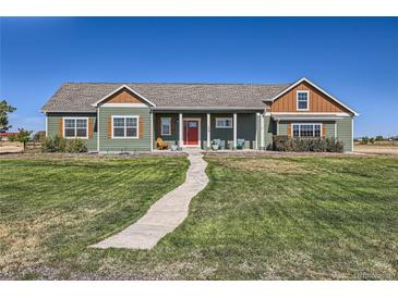 Ranch style home with green siding and red door at 738 S Main St, Byers, CO 80103