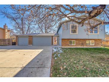 Brick ranch home with attached three-car garage and landscaped yard at 8160 W 81St Pl, Arvada, CO 80005