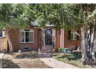 Brick home with a charming front porch and landscaped yard at 2371 Locust St, Denver, CO 80207