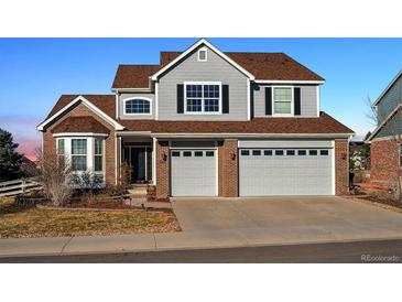 Two-story house with gray siding, brown roof, and a two-car garage at 325 Crosshaven Pl, Castle Rock, CO 80104