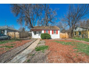 Cute bungalow with red trim, landscaped yard, and wood fence at 1565 Xanthia St, Denver, CO 80220