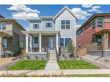 Two-story home with light blue and gray siding, brick accents, and a front porch at 21278 E 63Rd Dr, Aurora, CO 80019