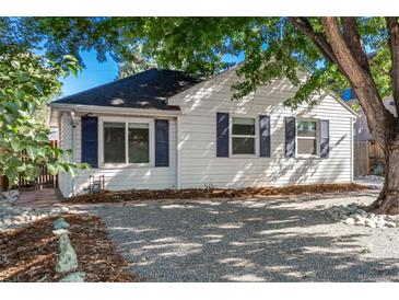 Charming white house with blue shutters, gravel driveway, and mature trees at 1160 S Monroe St, Denver, CO 80210