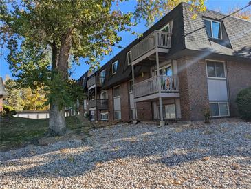 Brick apartment building with balconies and landscaping at 140 E Highline Cir # 203, Centennial, CO 80122