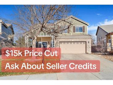 Two-story house with attached garage, landscaping, and large driveway at 7306 S Nucla St, Aurora, CO 80016