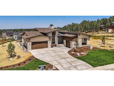 Luxury home with modern exterior, two-car garage, and landscaped yard at 9737 Majestic Oak Dr, Parker, CO 80134