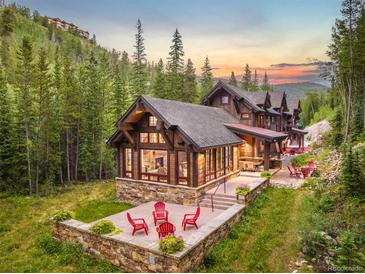 Luxury home nestled in the mountains with stone patio and seating at 1003 Boreas Pass Rd, Breckenridge, CO 80424