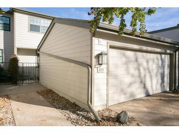 View of the property's garage, with a spacious single car garage and additional parking at 7900 W Layton Ave # 833, Littleton, CO 80123