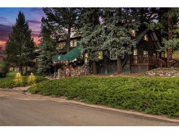 Exterior of charming lodge-style home nestled in a wooded area at 27425 Spruce Ln, Evergreen, CO 80439
