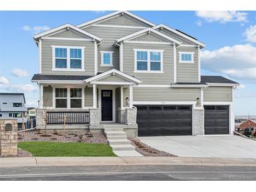 Two-story house with gray siding, black garage doors, and a landscaped front yard at 1136 Hillside Ln, Louisville, CO 80027