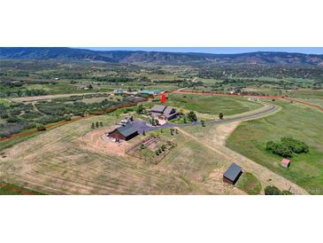 Aerial view of property showcasing home, expansive land, and mountain views at 934 S Perry Park Rd, Sedalia, CO 80135