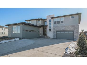 Modern two-story home with a three-car garage and a paved driveway at 3564 Doubletrack Ln, Castle Rock, CO 80108