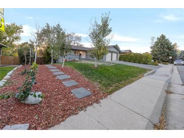 Landscaped front yard with walkway to the house at 3955 S Uinta St, Denver, CO 80237