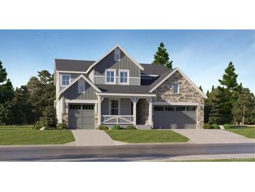 Two-story home with gray siding, stone accents, and a three-car garage at 1219 Sunrise Dr, Erie, CO 80516