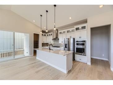 Modern kitchen with white cabinets, quartz countertops, stainless steel appliances, and a large island at 1881 Grayside Cir, Castle Rock, CO 80109