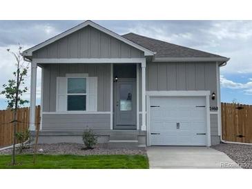 Simple ranch home with gray siding and a two-car garage at 2460 Christina St, Fort Lupton, CO 80621