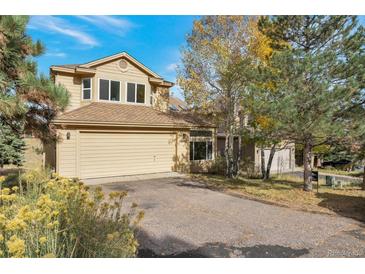 Two-story house with beige siding, attached garage, and landscaping at 24087 Deer Valley Rd, Golden, CO 80401