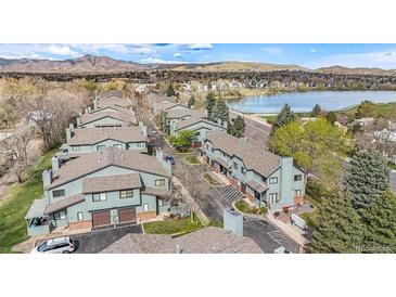 Aerial view of townhouses near a lake with mountain views in the background at 10330 W Jewell Ave # A, Lakewood, CO 80232