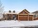 Two-story home with a snow-covered front yard and attached two-car garage at 11766 S Breeze Grass Way, Parker, CO 80134