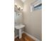 Modern powder room with pedestal sink and wood-look tile floor at 3425 W 16Th Ave, Denver, CO 80204