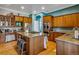 Large kitchen featuring wood cabinets, granite countertops, and island with cooktop at 10364 Carriage Club Dr, Lone Tree, CO 80124