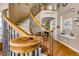 Close-up view of an elegant curved staircase with wood railing and wrought iron spindles at 10364 Carriage Club Dr, Lone Tree, CO 80124
