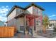 Two-story home with gray and red siding, a covered porch, and a fenced yard at 21124 E 63Rd Dr, Aurora, CO 80019