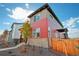 Contemporary two-story home with gray and red siding, and a fenced yard at 21124 E 63Rd Dr, Aurora, CO 80019