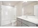 Clean bathroom with gray vanity, white tile, and bathtub at 21124 E 63Rd Dr, Aurora, CO 80019