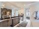 Elegant bathroom with double vanity, stone wall, and view to bedroom at 11364 Birolli Pl, Littleton, CO 80125