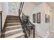 Basement stairs with modern metal railing and stone accent wall at 11364 Birolli Pl, Littleton, CO 80125