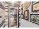 Built-in wine cooler with wood wall accents and wine-themed artwork at 11364 Birolli Pl, Littleton, CO 80125