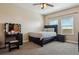 Spacious bedroom with a queen bed, vanity, and two windows at 54333 E County Road 26, Strasburg, CO 80136