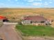 Aerial view of a ranch-style home with a large yard and outbuildings at 54333 E County Road 26, Strasburg, CO 80136