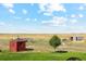 Farm yard with various outbuildings, including a red shed and a chicken coop at 54333 E County Road 26, Strasburg, CO 80136