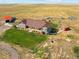 Aerial view of a ranch home, showcasing its landscaping and surrounding land at 54333 E County Road 26, Strasburg, CO 80136