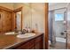 Bathroom with double sinks, wood cabinets, and a shower/tub combo at 54333 E County Road 26, Strasburg, CO 80136