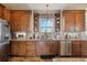 Bright kitchen boasts wood cabinets, granite counters, and a large window at 54333 E County Road 26, Strasburg, CO 80136