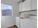 Laundry room with washer, dryer, and upper cabinets at 4572 Walden Way, Denver, CO 80249