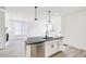 Modern kitchen island with dark countertop, stainless steel dishwasher, and sink at 9360 Bahama Ct, Commerce City, CO 80022