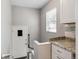 Small kitchenette with granite countertop and white cabinets at 1538 Oneida St, Denver, CO 80220