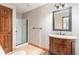 Bathroom with walk-in shower, wood vanity, and a large mirror at 102 Staghorn Way, Franktown, CO 80116