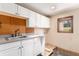 Laundry room with white cabinets, sink, and window at 102 Staghorn Way, Franktown, CO 80116