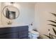 Modern bathroom with a round mirror and dark gray vanity at 2020 Arapahoe St # 950, Denver, CO 80205